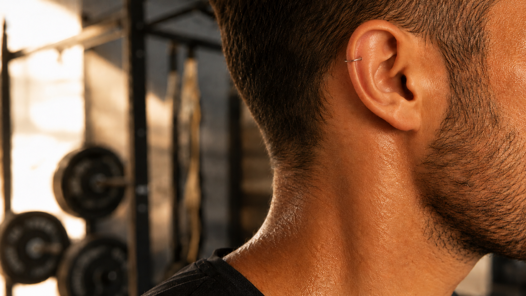 Homme avec piercing hélix pendant l'entraînement — conseils piercing et sport