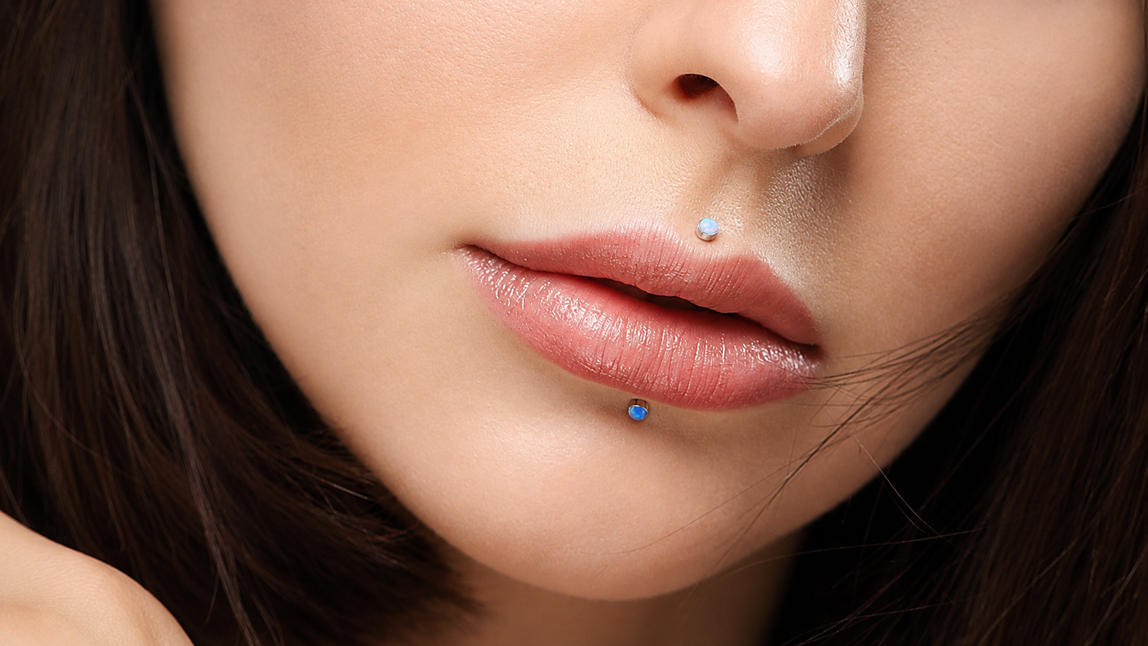 Jeune femme avec deux piercings de lèvre : un labret et un médusa