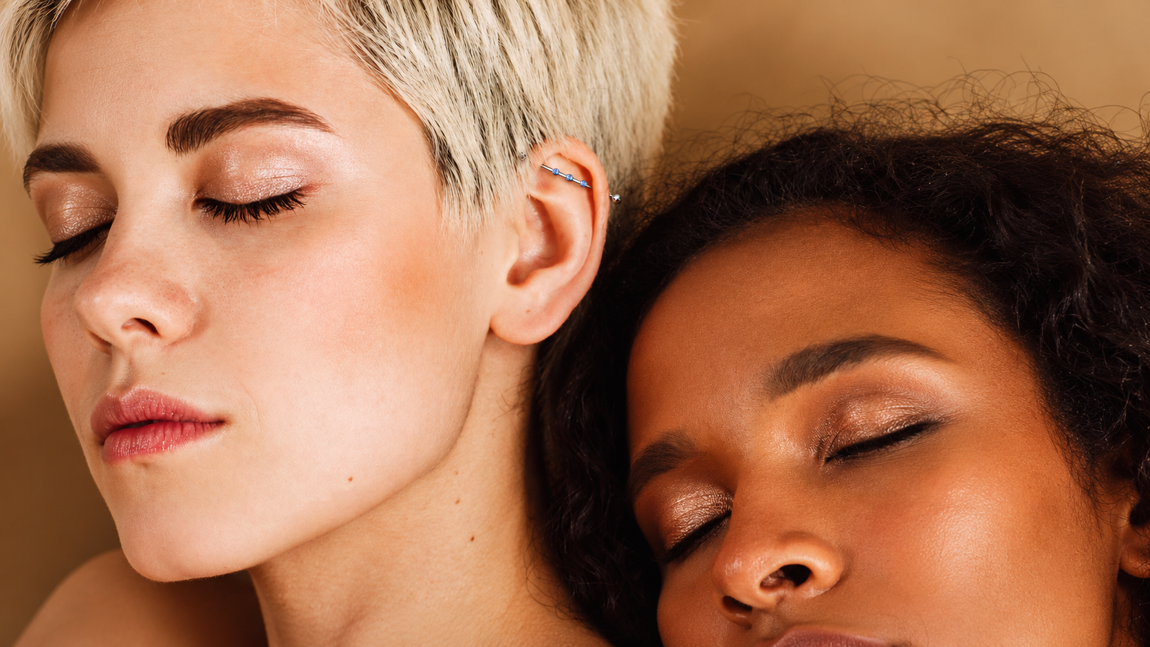 Deux femmes portant des piercings d’oreille, dont un piercing industriel avec pierres bleues